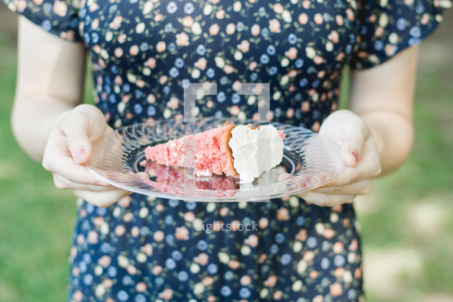 a woman holding a slice of cake on a plate 