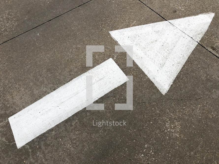 arrow painted on ground signifying up, guidance, direction