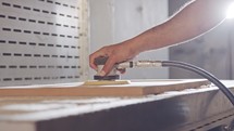 Slow motion of a worker polishing a cabinet door in a furniture factory
