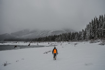 A man backpacking in the snow. 