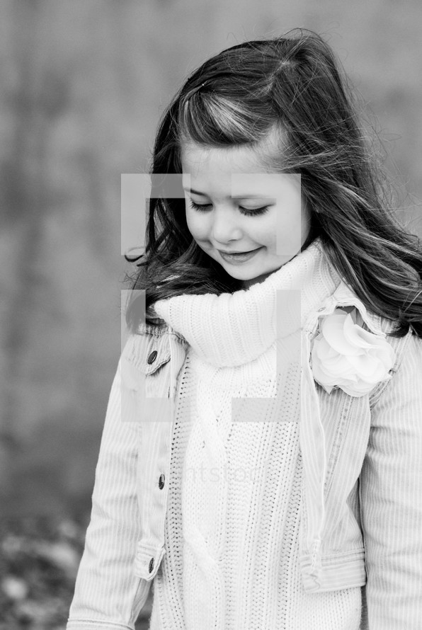 a little girl in a sweater and jacket 