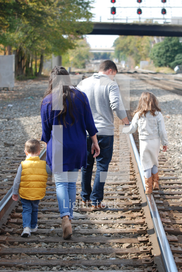 a family walking on railroad tracks 