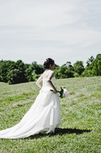 a bride walking through grass
