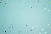 Turquoise background with colorful, shiny heart confetti