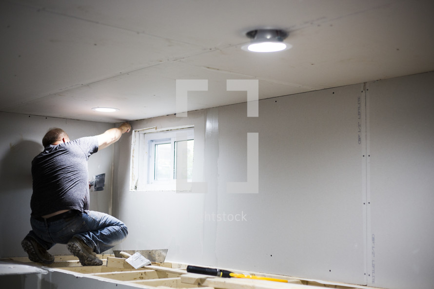 a man putting up drywall 