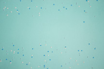Turquoise background with blue and white snowflake confetti