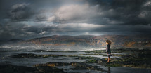 a child standing on a shore 