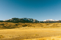 pasture and snow capped mountain peaks 
