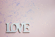 word love and glitter on a pink background 