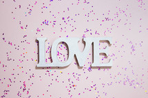 word love and glitter on a pink background 