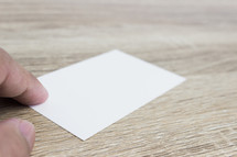 a hand holding a blank business card 