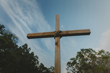 A large wooden cross against a blue sky.