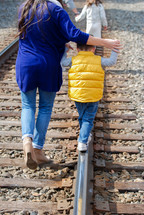 family walking on train tracks 