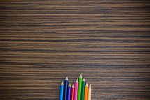 colored pencils on a wooden desk 