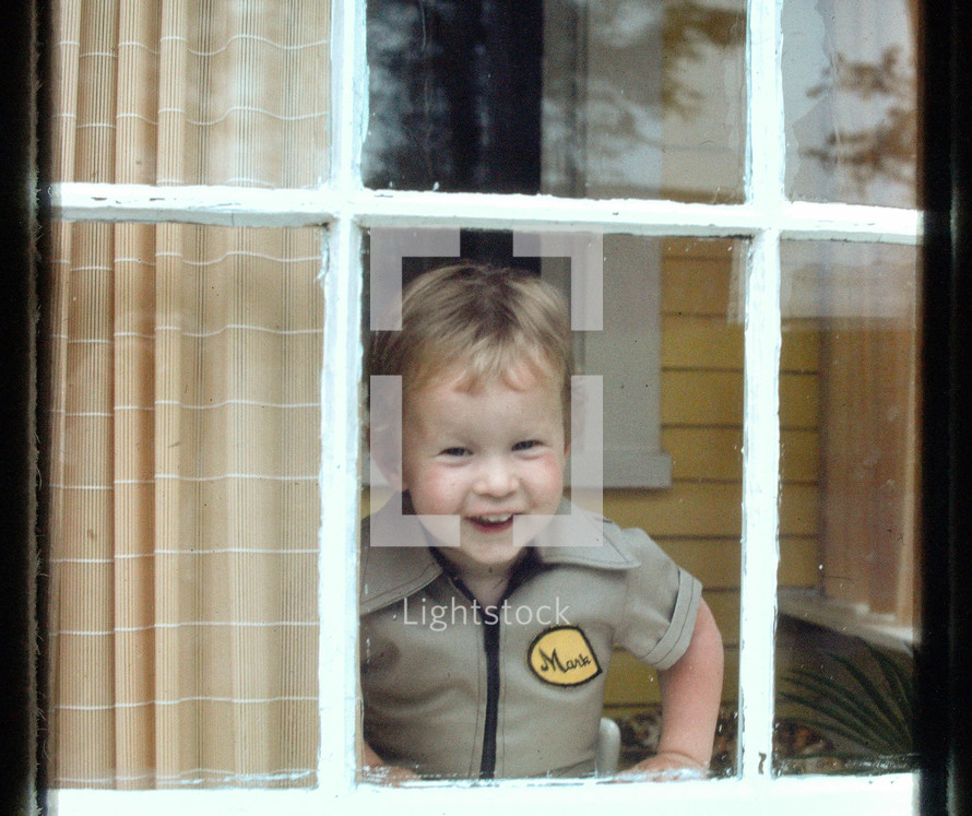 vintage photo of a child looking out a window 