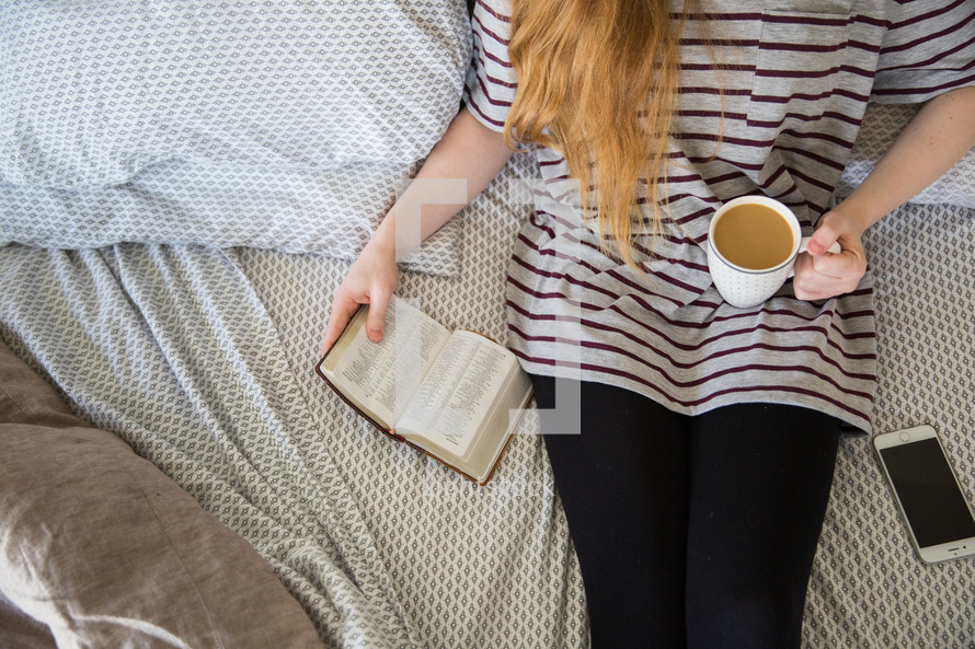 girl sitting on a bed with coffee reading a Bible 