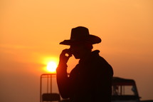 silhouette of a cowboy talking on a cellphone 