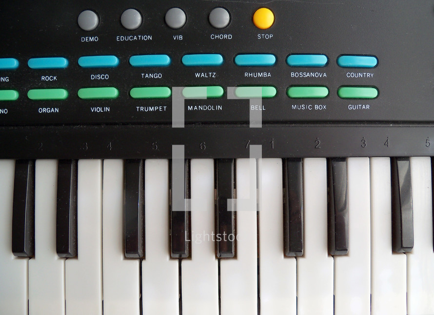 Upclose view of an electronic keyboard with piano keys, programmable buttons for different styles of music and synthesized sounds to emulate for a concert or recording session for praise, worship and contemporary Christian music bands on tour or recording live in a recording studio. 