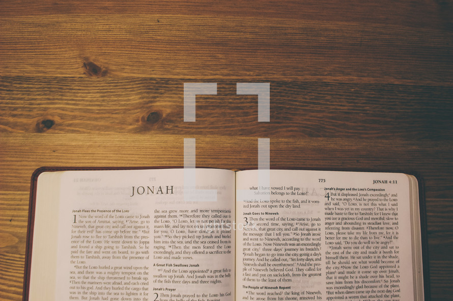 Bible on a wooden table open to the book of Jonah.