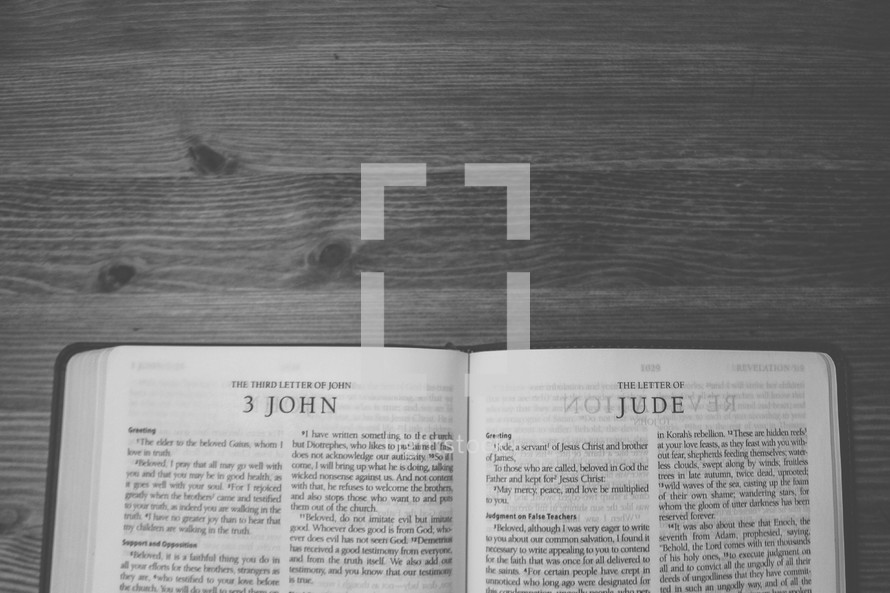 Bible on a wooden table open to the book of 3 John.