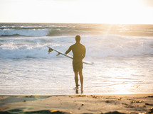 man with a surfboard on the beach 