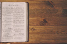 Bible on a wooden table open to the book of Jeremiah.