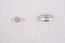 wedding band and engagement ring in snow