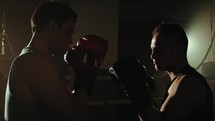 Athletes train fighting in the ring in the gym with boxing gloves
