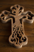 wooden cross with tree carving detail on a wood background 