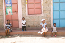 young family sitting on a stoop in Africa 