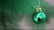 green Christmas ornament handing on a Christmas tree 