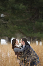 couple hugging outdoors in a field 