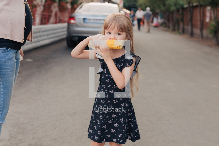 girl eating a corn on the cob