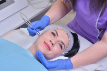 Young woman gets professional facial skin treatment in a professional beauty clinic