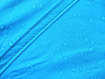 Blue rainproof tent sheet with morning rain drops