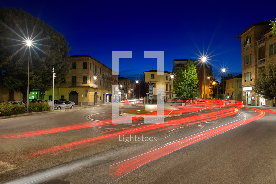 Car light trails on the crossroad during night in the city of Umbertide, Italy