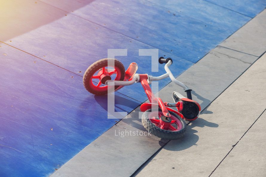 kid's bicycle lying on a skateboard ramp park