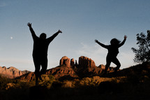 silhouettes jumping in a desert landscape 