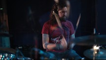 Drummer drumming on a drum set.