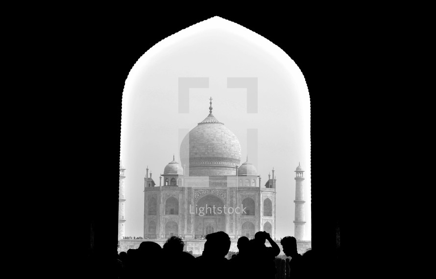 silhouettes of tourists in front of the Taj Mahal