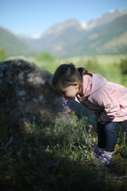 child smelling a flower 