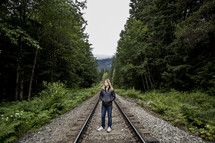 a woman standing on train tracks 