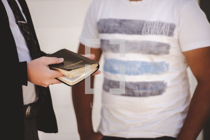 a man reading a Bible to a stranger 