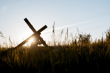 a man carrying the cross through a field 