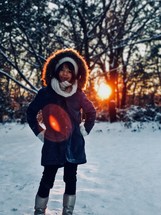 a girl in a coat standing in snow 