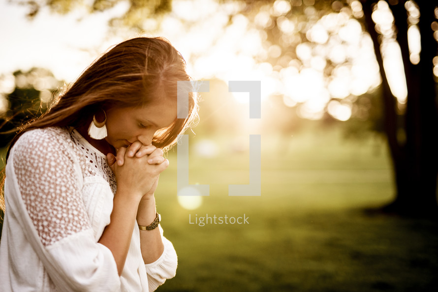 woman praying outdoors 