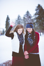 women praying outdoors in winter holding hands 