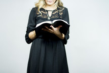 woman standing reading a Bible 
