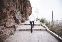 man walking up stone steps 