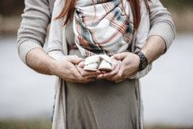 pregnant woman holding baby booties 